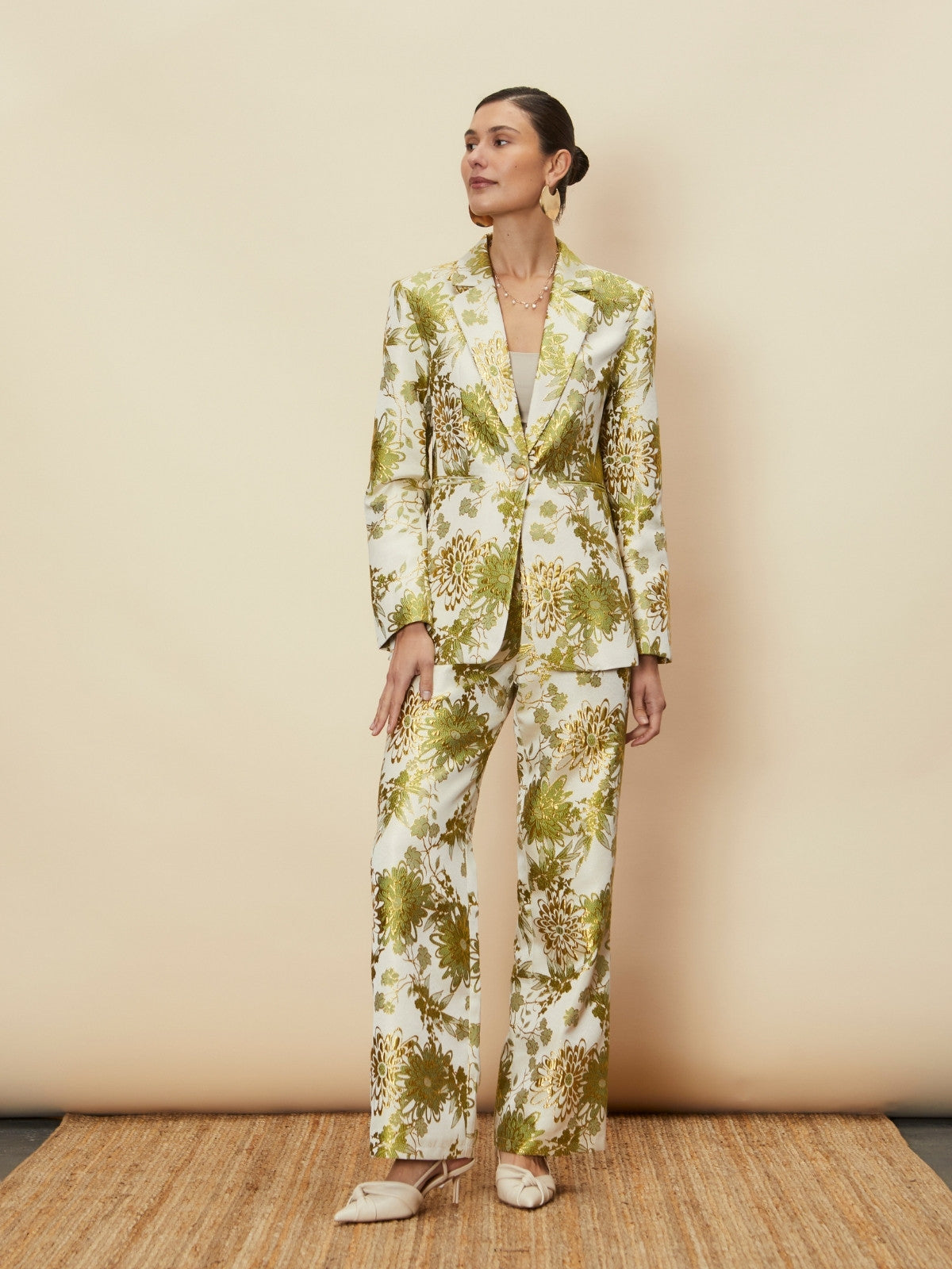 Woman wearing a floral suit against a beige background