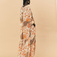 A back view - a woman  wearing La Maise Cannes maxi dress with seashell print.