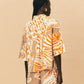 A young woman wearing La Maise Cannes shirt with seashell print on beige background.