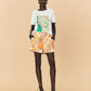 A woman wearing La Maise Cannes shorts  with seashell print.