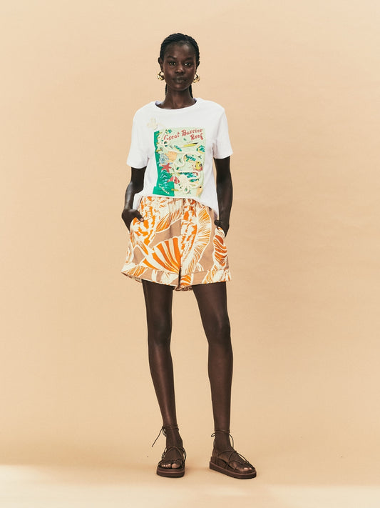 A woman wearing La Maise Cannes shorts  with seashell print.