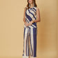 A woman standing in striped wide-leg Mila Pants by La Maise Studio, showing the full length silhouette and soft vertical stripe pattern.