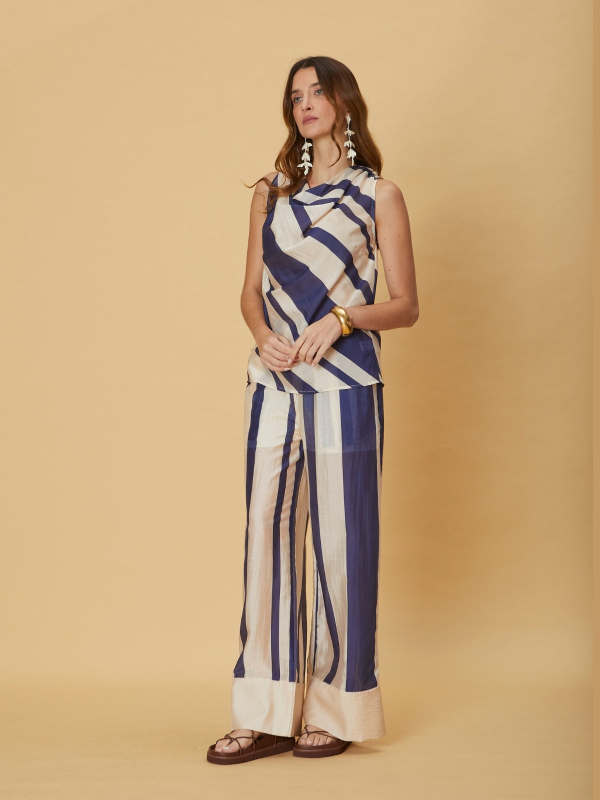 A woman standing in striped wide-leg Mila Pants by La Maise Studio, showing the full length silhouette and soft vertical stripe pattern.