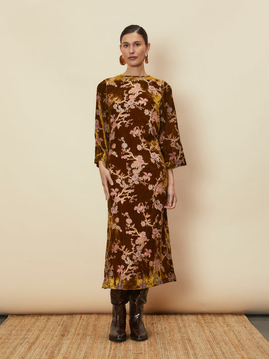 A young woman wearing the Bianca Velvet Midi Dress by La Maise Studio, a brown floral velvet midi dress with three-quarter sleeves and a relaxed silhouette.
