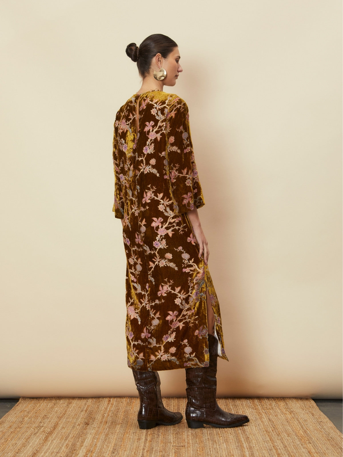 Back view of a model wearing the Bianca Velvet Midi Dress by La Maise Studio, highlighting the midi length, floral velvet fabric, and side hem split.